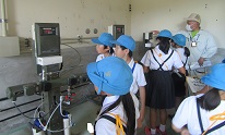 美川浄水場２　濃度を設定する機械を見つめる子供たち