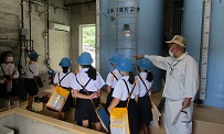 美川浄水場３　滅菌処理をする機械を見ている子どもたち