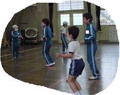 高学年が低学年に教えながら縄跳びを練習しているところです。