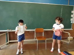 帽子を手に持つ子と教科書を読む子