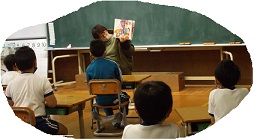 絵本の絵を見せながら読み聞かせをしています。