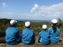 冒険の森終了後に視界に広がる青空と海を眺める子どもたち