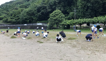 親子で一緒に校庭の草を抜いています
